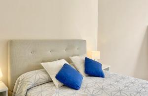 a bed with blue and white pillows on it at Marbella del Mar II Beachfront- EaW Homes in Marbella