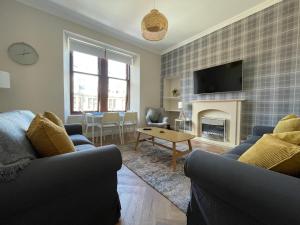 a living room with two couches and a fireplace at The Haven in Greenock