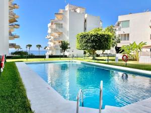 a swimming pool in front of a building at Marbella del Mar II Beachfront- EaW Homes in Marbella
