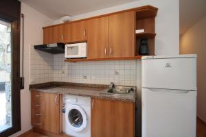 a kitchen with a white refrigerator and a sink at Ransol 3.6 Apartamento 1 km pistas Tarter in Canillo