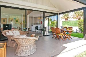 uma sala de estar com cadeiras de vime e uma mesa em Chalet Maria em Maspalomas