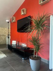 a living room with a tv on a red wall at Appart en duplex climatisé cœur de ville in Périgueux