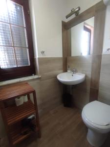 La salle de bains est pourvue de toilettes blanches et d'un lavabo. dans l'établissement Simo Amour, à Lercara Friddi