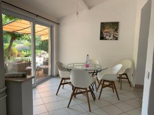 a dining room with a glass table and white chairs at Villa avec Piscine et Vues Imprenables in Villars