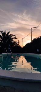 an empty swimming pool with a sunset in the background at Simo Amour in Lercara Friddi