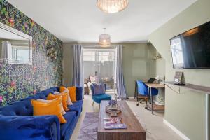 salon z niebieską kanapą i pomarańczowymi poduszkami w obiekcie BridgeCity Cheerful 3 bedroom home in Nuneaton w mieście Nuneaton