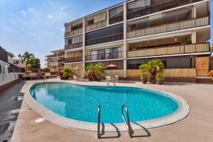 a swimming pool in front of a building at Kona Plaza 210 in Kailua-Kona