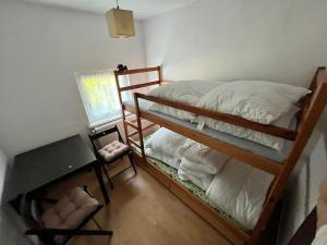 a bedroom with two bunk beds and a desk at Dom w Borach in Legbąd