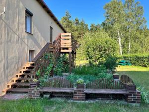 a garden with a wooden staircase next to a house at Dom w Borach in Legbąd
