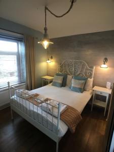 a bedroom with a white bed with blue pillows at Ty Rosa Rooms in Cardiff