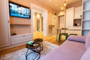 a living room with a couch and a tv on the wall at Black Gate - Quiet Studio in the Heart of Old Town with Free Private Secured Parking in Braşov
