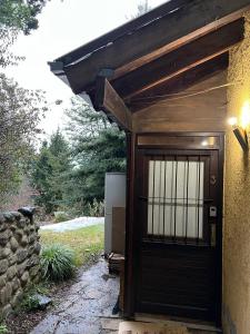 garaje de madera con puerta y pared de piedra en Ivy Bariloche en San Carlos de Bariloche