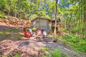 uma cabana na floresta com cadeiras e uma fogueira em Otto Mountain Cabin Near Hiking with Fire Pit and Deck em Otto