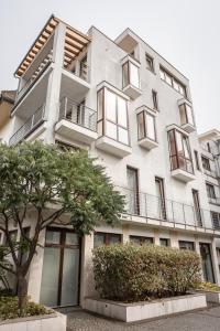 un edificio blanco con un árbol delante en Kaiser Residence en Baja