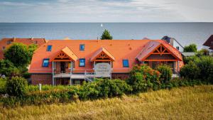 ein Haus mit einem orangenen Dach und dem Meer in der Unterkunft Ich kenne ein Haus am Meer in Putbus