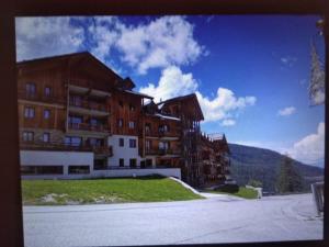 un gran edificio de apartamentos en medio de una calle en T2 Les orres 1800 : pied des pistes avec piscine en Les Orres