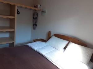 a bed with a wooden headboard in a bedroom at T2 Les orres 1800 : pied des pistes avec piscine in Les Orres