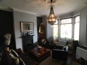 sala de estar con sofá y lámpara de araña en Ty Rosa Rooms, en Cardiff