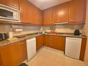 una cucina con armadietti in legno ed elettrodomestici bianchi di Tucamp 3,7 a 30 mts de Funicamp a Encamp