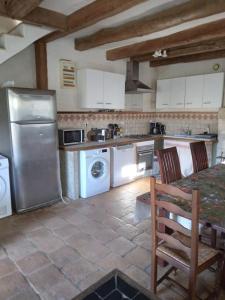 eine Küche mit einem Kühlschrank und einem Tisch mit Stühlen in der Unterkunft La Chapelle in Chanceaux-sur-Choisille