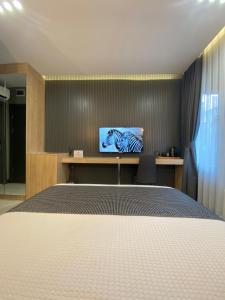 Santra Bosphorus Hotel في إسطنبول: غرفة نوم بسرير وتلفزيون على جدار