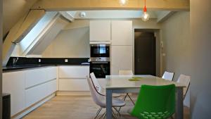 a kitchen with a table and chairs in a room at Little Suite - Simone in Lille