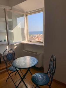 - une table et deux chaises dans une chambre avec fenêtre dans l'établissement Minerva Lodge - Panoramico centro storico Terracina, à Terracine