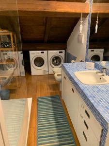 y baño con lavabo, lavadora y secadora. en Minerva Lodge - Panoramico centro storico Terracina, en Terracina