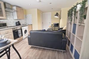 a living room with a black couch in a kitchen at Church Rd in Bristol