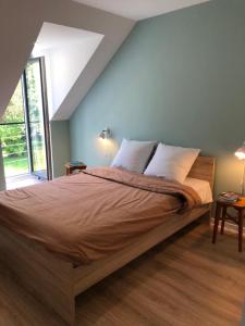 Longère bretonne chaleureuse près de la mer في Yvias: غرفة نوم بسرير كبير بجدران زرقاء