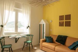 salon z kanapą i stołem w obiekcie VITEDIMARE APARTMENT SOLE - SUN w mieście Muggia