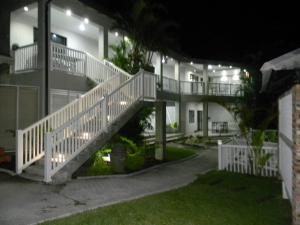 a house with a white staircase at night at Peace Cottages Uvongo. in Uvongo Beach