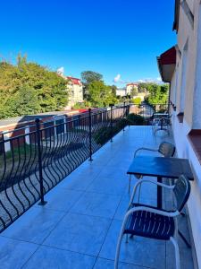 einen Balkon mit einem Tisch und Stühlen auf einem Gebäude in der Unterkunft Hotel i Restauracja „KRISTAL” in Braniewo