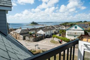 a view from the balcony of a town with the ocean at Marazion Attic in Marazion
