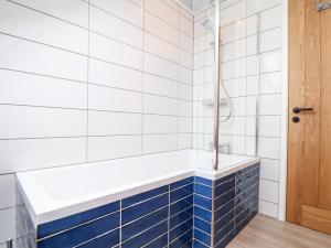 a bathroom with blue and white tiles and a tub at Marazion Attic in Marazion +27 photos