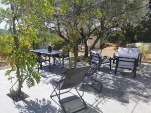 een patio met een tafel, stoelen en bomen bij Villa Coris in Draguignan