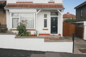 a white house with a black door on a street at 39 Court Rd in Bristol