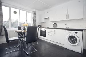 a kitchen with a table and a washing machine at Druids Hill in Bristol