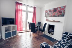 a living room with a table and chairs and a television at 4 Elmhurst Avenue in Bristol