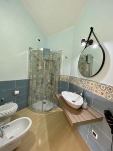 een badkamer met een douche, een wastafel en een spiegel bij Demetra Residence in Enna