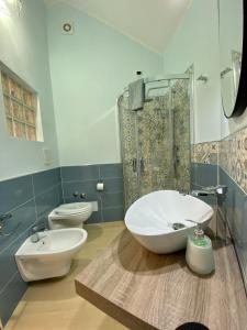 een badkamer met 2 toiletten, een wastafel en een douche bij Demetra Residence in Enna