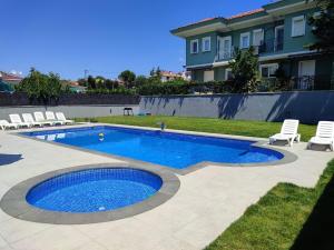 a swimming pool in a yard with chairs and a house at Beachside Villa in Silivri