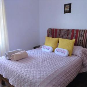 1 dormitorio con 1 cama con 2 almohadas y 1 sofá en Piso de Kireyna, en Cusco