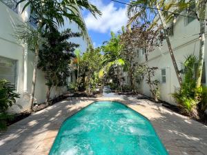 ein Pool vor einem Haus mit Palmen in der Unterkunft North Beach Hotel in Fort Lauderdale
