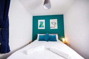 a bedroom with a white bed with blue accents at 56b Mina rd in Bristol