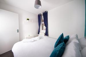 a white bed with blue pillows in a room at 56b Mina rd in Bristol