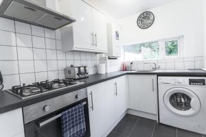 a white kitchen with a washer and dryer at Three Bed - Suitable for Contractors- Large Groups in Bristol