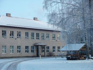 a large brick building with snow on the ground at Roosu Talu Accommodation in Sulbi