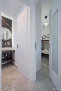 a hallway with a white wall and a mirror at Oresti's Villa Near Airport & Beach in Artemida