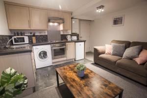 cocina y sala de estar con sofá y mesa en Flat 1, 4 Warden Rd, en Bristol